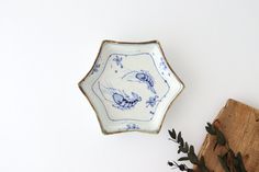 a blue and white plate sitting on top of a wooden box next to a plant