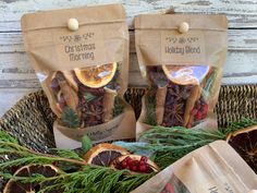 two bags of dried herbs sitting on top of a basket filled with oranges and other fruits