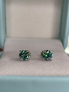 New In!  Beautiful Green Moissanite Stud Earrings in Sterling Silver 925 Weight: 0.8CT+0.8CT  (6mm in diameter each).  Cut: Round Brilliant  Color:Blue-Green, Green  Clarity:VVS Base metal: Sterling Silver 925 Plating: Rhodium  Nickel free, hypoallergenic  Will come with a GRA report (information about the stone) and a Box ready for a gift. *Will pass a diamond tester!  Will be shipped from Los Angeles CA within 1-2 business days ---------------------------------------------- Classic Green Sterling Silver Diamond Earrings, Anniversary Green Diamond Sterling Silver Earrings, Anniversary Green Diamond Earrings In Sterling Silver, Gia Certified Green Diamond Earrings Gift, Green Brilliant Cut Round Diamond Earrings, Green Sterling Silver Diamond Earrings With Prong Setting, Green Diamond Earrings With Brilliant Cut, Green Sterling Silver Diamond Earrings For Anniversary, Gift Green Diamond Earrings In Sterling Silver