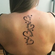 the back of a woman's neck with two hearts and an inscription on it