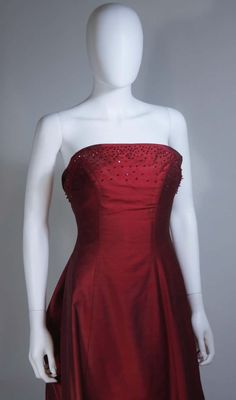 For Sale on 1stDibs - This Daniel James Cantu gown is composed of a burgundy raw silk chiffon with bead applique and flower at the center back. There is a center back zipper Fitted Burgundy Ball Gown Evening Dress, Fitted Burgundy Gown For Evening, Embellished Silk Prom Gown, Embellished Silk Gown For Prom, Embellished Burgundy Wedding Dress, Embellished Silk Evening Dress For Prom, Burgundy Silk Wedding Dress, Fitted Burgundy Silk Dress, Silk Embellished Gown For Prom Season