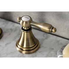 a close up of a faucet on a marble counter with soap dispenser