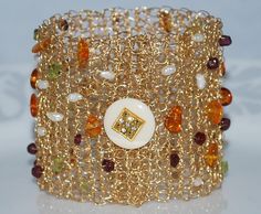 a close up of a gold bracelet with beads