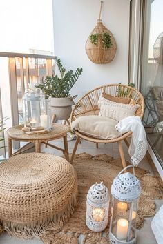 a balcony with wicker furniture and candles on the floor next to potted plants