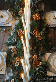 the table is set with candles and orange slices