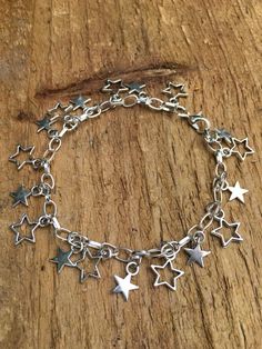 This pretty adjustable star charm bracelet features Tibetan silver dangling star charms on a silver plated chain. It would make a lovely gift for a girlfriend, best friend or loved one.Maximum length: 20cm, adjustable to any length less than 20cm.How’s it packed?Your item will be packaged in a purple organza bag. Your order will then be shipped in a padded envelope. Silver Star-shaped Jewelry With Dangling Charms, Metal Charm Bracelet With Star Charm, Metal Star Charm Bracelet Gift, Trendy Silver Charm Bracelet With Dangling Charms, Adjustable Star Charm Bracelet, Adjustable Metal Charm Bracelet With Star Charm, Trendy Silver Star Bracelet, Trendy Silver Jewelry With Star Charm, Trendy Silver Jewelry For Best Friend Gift