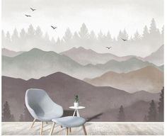 a chair and table in front of a wall mural with birds flying over the mountains