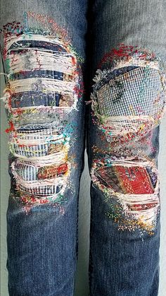 the jeans are ripped and have been decorated with different colored patches on them, as well as holes in the fabric