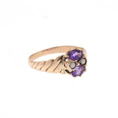 This lovely edwardian era ring features two vibrant purple oval amethysts. They measure about 5x3mm and are set horizontally. Between the two gemstones are two delicate seed pearls. The ring is a beautiful rosey gold. probably 12-14k. Hand engraved detail on each side add uniqueness to this vintage ring. It is perfect for a February birthstone ring. Size: 5.25 - Sizing smaller and larger up to two sizes is included. For larger sizes please inquire. Please see the Additional Policies section for Antique Oval Three Stone Rings, Heirloom Purple Ring With Rose Cut Diamonds, Victorian Style Oval Purple Amethyst Ring, Amethyst Ring With Rose Cut Diamonds, Oval Shape, Victorian Style Purple Oval Amethyst Ring, Heirloom Oval Purple Birthstone Ring, Heirloom Purple Oval Birthstone Ring, Antique Oval Amethyst Multi-stone Ring, Victorian Oval Amethyst Ring With 17 Jewels