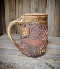 a brown ceramic mug sitting on top of a wooden table