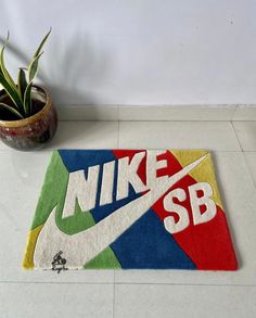 a colorful rug with the word nike sb on it next to a potted plant