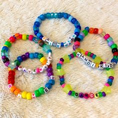 three bracelets with words on them sitting on a white carpet next to each other