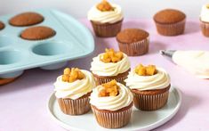 cupcakes with white frosting and pineapple toppings are on a plate