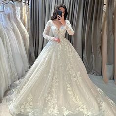 a woman is taking a selfie in her wedding dress at the bridal shop