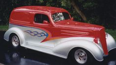 an old red and white car parked on the street