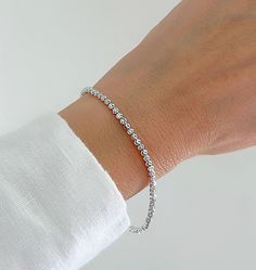 "Shiny And Bright 14K White Gold Moon Cut Ball Bead Bracelet. Diamond Cut Beads That Are Perfect For Layering Or Worn Alone. The Perfect Gift To Give. Jewelry Comes In A Cute Gift Box Ready To Present.  ▪️All Jewelry Is New And Inspected For Quality Assurance.  ▪️Jewelry Is Crafted In Genuine High Quality 14K Gold. ▪️We Do Not Sell Gold Plated.  Product Detail: Metal: 14K White Gold Width: 2.5MM Length: 7\" Inch Closure: Lobster Claw Weight: 3.4 Grams ✨ Feel free To Ask Me Any Questions Or Concerns You May Have ✨ 🌈 Follow Me On Instagram @sarakayjewelry Thank You For Visiting My Shop." Elegant Crystal Bracelet With Round Beads And Jubilee Style, Elegant Bracelet With Round Faceted Beads, Elegant Round Bracelets With Faceted Beads, Elegant Beaded Chain Bracelet For Everyday, Elegant Rosary Bracelet With Spacer Beads, Elegant Everyday Beaded Chain Bracelet, Elegant Rondelle Crystal Bracelet With Spacer Beads, Minimalist Single Strand Beaded Bracelets With Round Beads, Elegant Crystal Bracelet With Spacer Beads