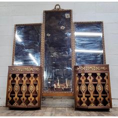 two large mirrors sitting next to each other on top of a wooden floor