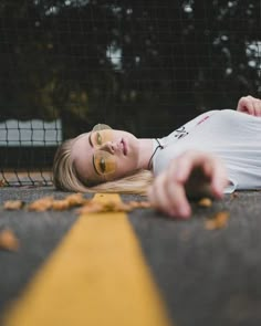 a woman laying on the ground with her eyes closed