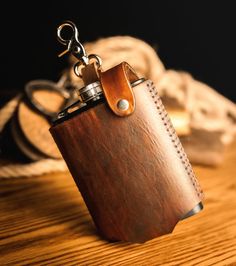 a brown leather flask with a keychain hanging from it