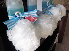 some candles are sitting on a table with white ruffles and blue ribbon around them