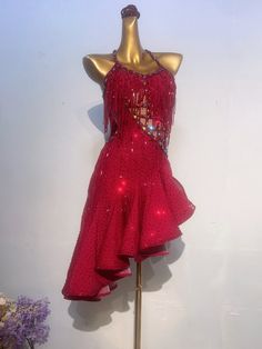 a mannequin wearing a red dress with sequins on it