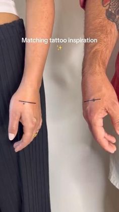 two people holding hands with tattoos on them