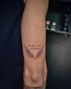 a person with a tattoo on their arm that says trust the process