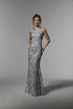 Name: Embroidered Net Sheath with Gunmetal BeadingSultry evening gown skims the body in a fitted sheath silhouette with a halter neckline that shows off your arms and shoulder and a beautiful illusion back. The embroidered net features an abstract pattern with the subtle sparkle of edgey gunmetal beading. Matching stole included. Halter Evening Dress, Madeline Gardner, Beaded Evening Gowns, Mother Of The Bride Dresses Long, Black Tie Wedding Guests, Mother Of The Bride Gown, Mother Of Groom Dresses, Mob Dresses, Mori Lee