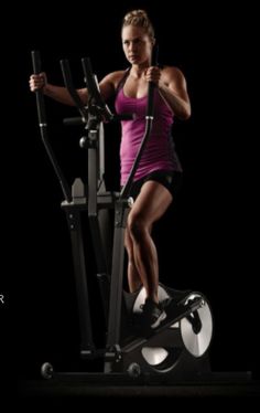 a woman is riding an exercise bike on a black background with the caption,