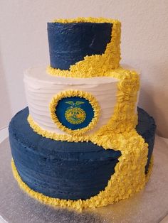 a three tiered cake with blue and yellow frosting