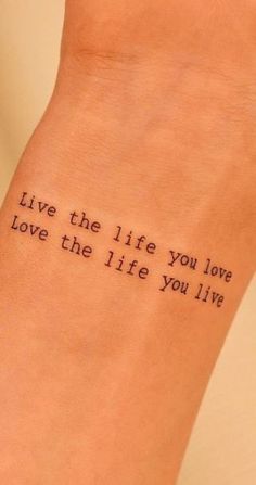 a woman's foot with a tattoo saying live the life you love, love the life you live