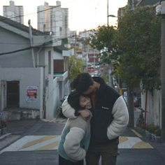 a man and woman kissing on the street