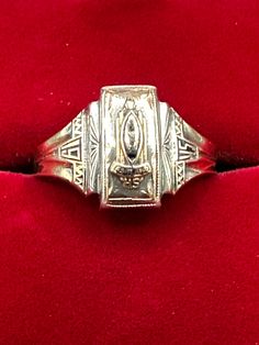 This offering was a commemoration of a very special occasion in 1945.  This senior ring is hallmarked 10K and Sterling guaranteed to be such. It also has the maker's mark "Jostens", one of the premier class ring manufacturers.  There are initials inscribed "B.J.M" as well. The crest features an "A" and underneath, the word "Ashland". The art deco styling is prevalent not only on the top of the ring but also the b the sides. In addition, the sides feature "19" on one side and "45" on the other.  The top of the ring measures approximately 12mm x 8mm. It is a size 6 3/4 and weighs in at 4.92 grams. What a great piece of history! Vintage Hallmarked Rings For Memorial, Antique 14k Stamped Signet Ring For Commemoration, Antique 14k Gold Engraved Ring For Commemoration, Vintage 14k Engraved Ring For Commemoration, Vintage 14k Stamped Engraved Ring For Commemoration, Vintage 14k Gold Rings For Commemoration, Vintage Engraved Ring Stamped 14k For Commemoration, Heirloom Engraved Ring For Commemoration With Hallmarks, Antique 14k Gold Signet Ring For Commemoration