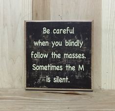 a wooden sign that says, be careful when you bindly follow the masses sometimes the m is silent