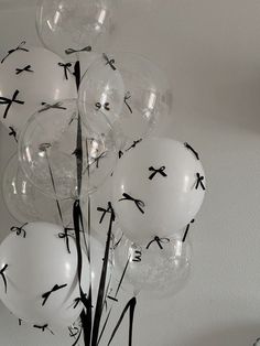 white balloons with black crosses on them are in a clear vase against the wall and ceiling