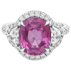 A charming three-stone engagement ring style, showcasing an AGL certified oval cut pink sapphire weighing 5.73 carats, set on a four claw prong setting. Flanked by epaulette diamonds weighing 0.56 carat total. Surrounded by a halo of round brilliant cut diamonds that continue on to the shank in a half-way design. Accent diamonds weigh 0.84 carat total. Made with 18K white gold. Size 6.5 US, resizable upon request. Roman Malakov is a custom house, specializing in creating anything you can imagine Pink Sapphire Ring Engagement, Contemporary Engagement Rings, Three Stone Diamond, Three Stone Engagement, Beautiful Engagement Rings, Three Stone Engagement Rings, Engagement Ring Styles, Halo Diamond Engagement Ring, Three Stone Rings