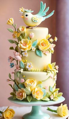 a three tiered cake decorated with flowers and birds