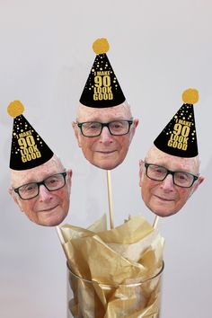 three party hats on top of each other in front of a cup filled with gold foil