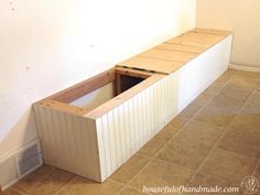 an unfinished bench is sitting in the middle of a room with tile flooring and white walls