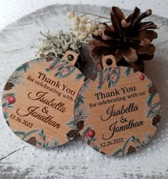 two wooden tags with pine cones and berries on them