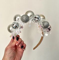 a hand holding a silver and white christmas decoration