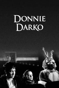 two people sitting next to each other in front of a rabbit mask on the cover of a book