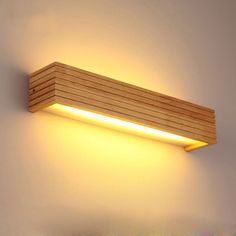 a wooden light fixture on the wall with dim lighting in it's center and bottom corner