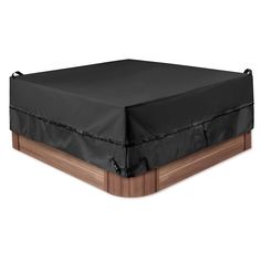 a bed with a black cover on top of it and wooden frame around the headboard