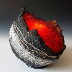 a black and red vase sitting on top of a table