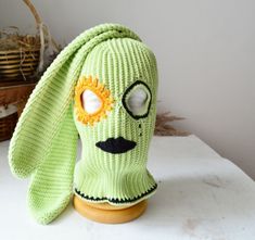 a green knitted hat with a dog's face on it