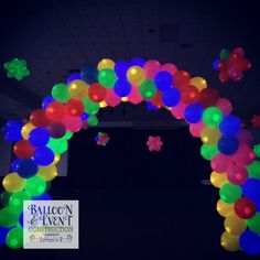 an arch made out of balloons in the dark