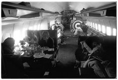 black and white photograph of people eating in an airplane