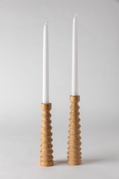 two white candles sitting next to each other