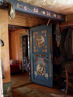 an old fashioned bedroom with wooden floors and painted walls, including a large blue door